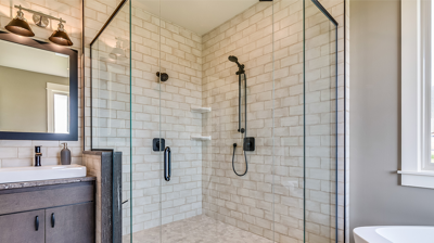 single vanity with copper lighting, large walk in shower