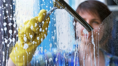 woman cleaning the glass shower doors