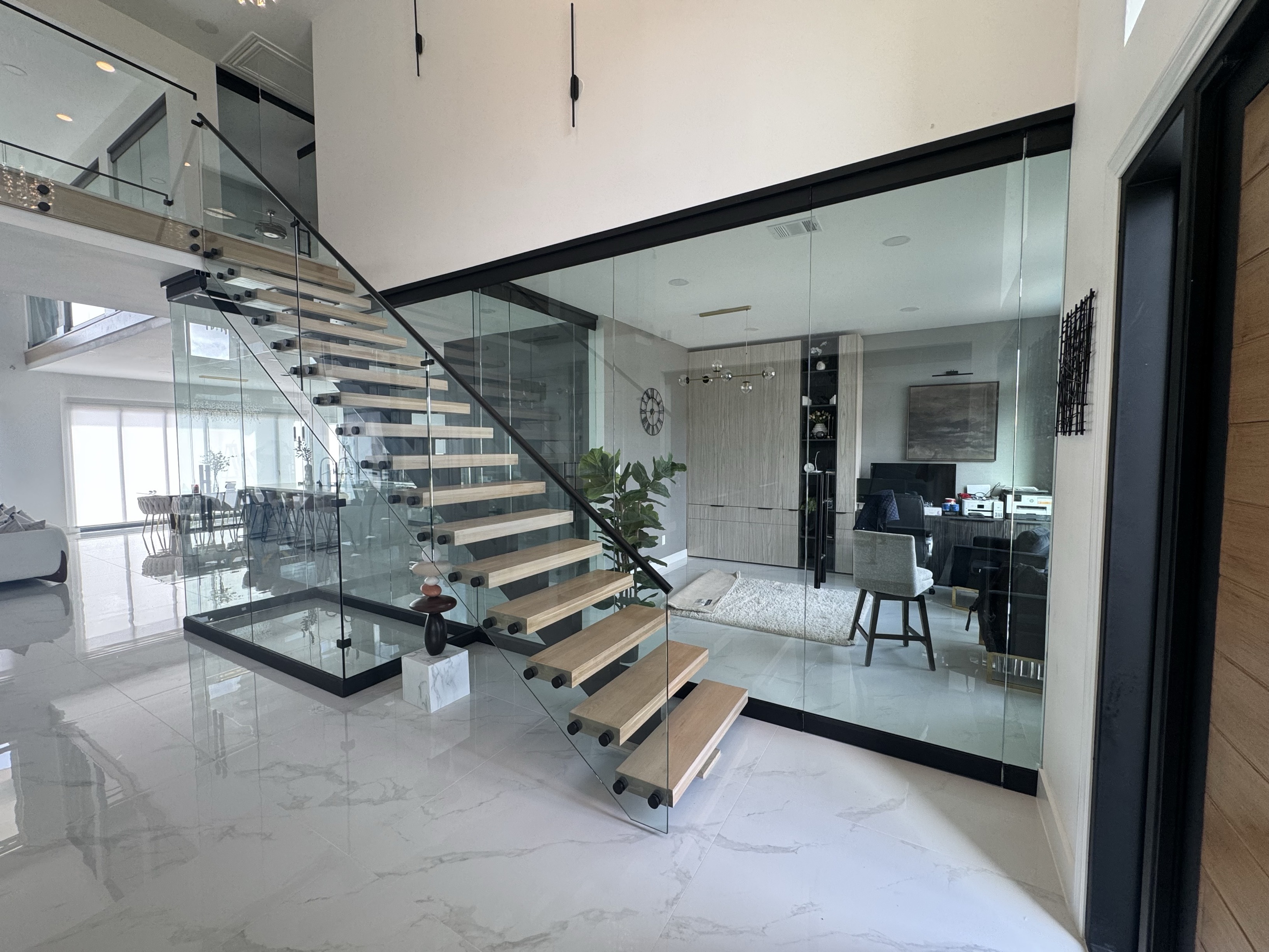 Entryway with a custom glass stair rail and room partition