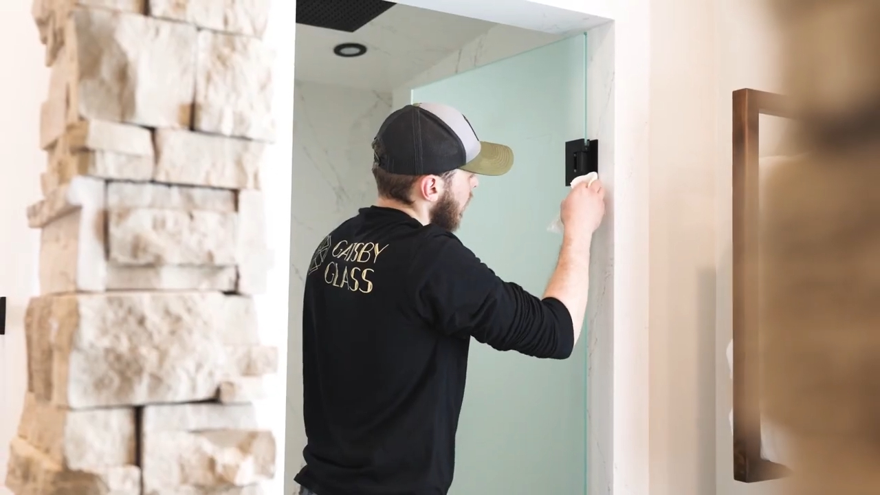 man installing glass shower door